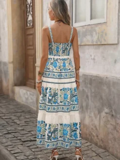 Robe longue d'été fluide à bretelles spaghetti et imprimé floral bleu pour femme avec nœud sur le devant et volants.