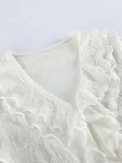 Robe longue moulante sirène en dentelle abricot col V transparent taille haute manches longues évasées et fente haute.