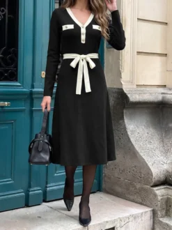 Robe midi en maille noire contrastée avec bordure blanche col en V poches ceinture à nouer à la taille manches longues coupe trapèze