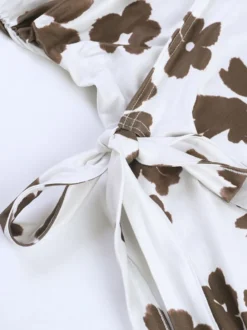 Robe mini moulante à fleurs blanches et marron bretelles spaghetti torsadées sur le devant et cordon de serrage latéral idéale pour une soirée en amoureux.