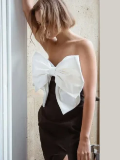 Robe noire chic à bretelles dos nu et sans manches ornée de nœuds idéale pour une soirée romantique.