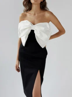 Robe noire chic à bretelles dos nu et sans manches ornée de nœuds idéale pour une soirée romantique.