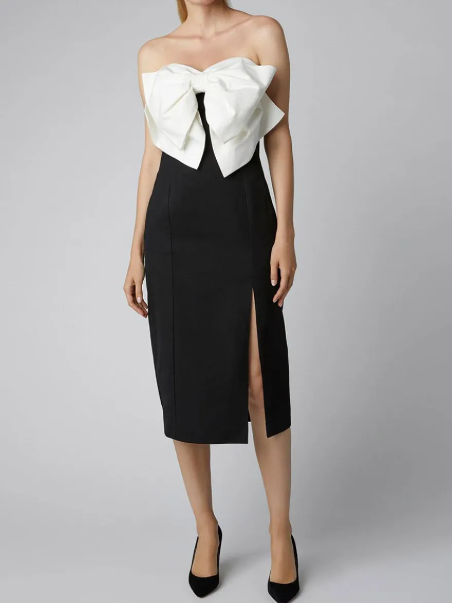 Robe noire chic à bretelles dos nu et sans manches ornée de nœuds idéale pour une soirée romantique.