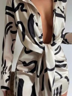Robe noire élégante à manches longues et coupe asymétrique idéale pour tous les jours.