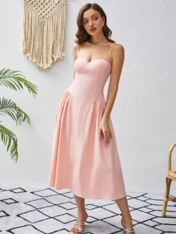 Robe rose élégante mi-longue sans manches à bretelles et col montant idéale pour une soirée en amoureux.