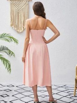 Robe rose élégante mi-longue sans manches à bretelles et col montant idéale pour une soirée en amoureux.