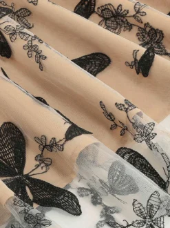 Robe rétro glamour années 50 noire bicolore à volants brodée sans manches col en V style rockabilly