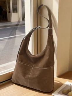 Sac hobo vintage en daim avec surpiqûres contrastées bandoulière ajustable et porte-monnaie intégré.