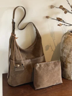 Sac hobo vintage en daim avec surpiqûres contrastées bandoulière ajustable et porte-monnaie intégré.