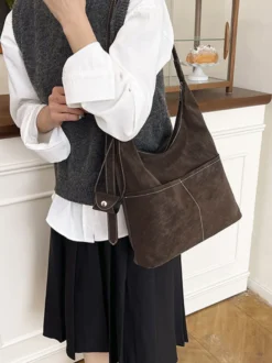 Sac hobo vintage en daim avec surpiqûres contrastées bandoulière ajustable et porte-monnaie intégré.