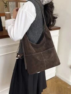 Sac hobo vintage en daim avec surpiqûres contrastées bandoulière ajustable et porte-monnaie intégré.