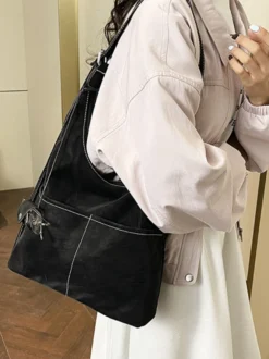 Sac hobo vintage en daim avec surpiqûres contrastées bandoulière ajustable et porte-monnaie intégré.