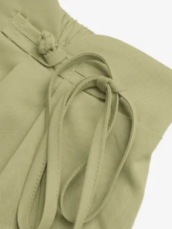 Short plissé taille haute pour femme asymétrique à nouer à la taille coupe ample et décontractée idéal pour l'été.